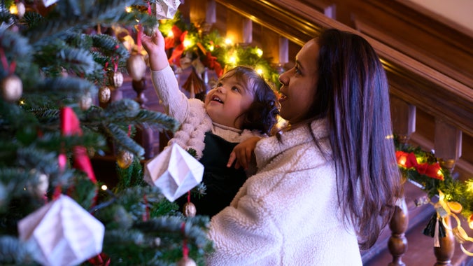 A woman and young child looking at a Christmas tree close up, Dyrham Park, South Gloucestershire